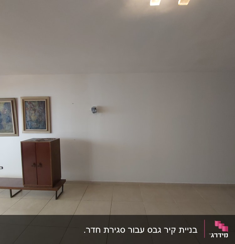 קיר גבס עם תמונות ותאורה עליונה